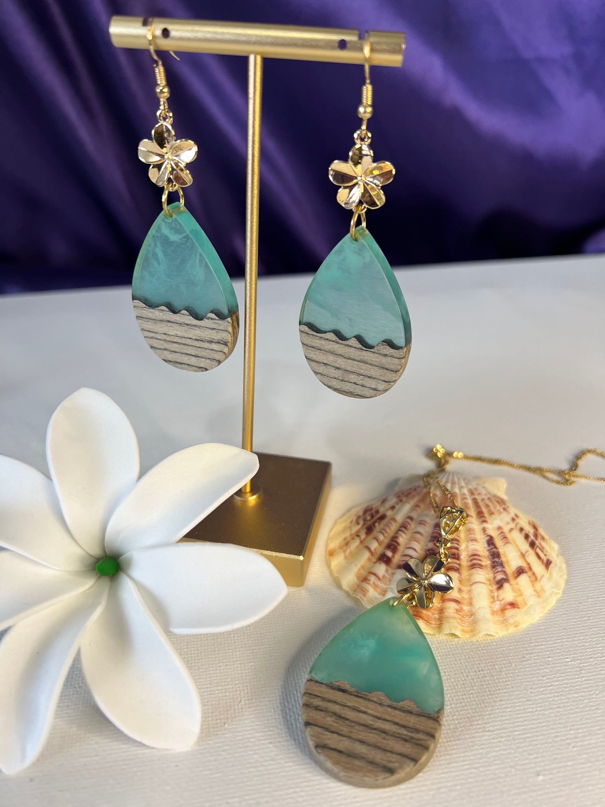 Teal risen ocean waves with wood complemented with plumeria flower