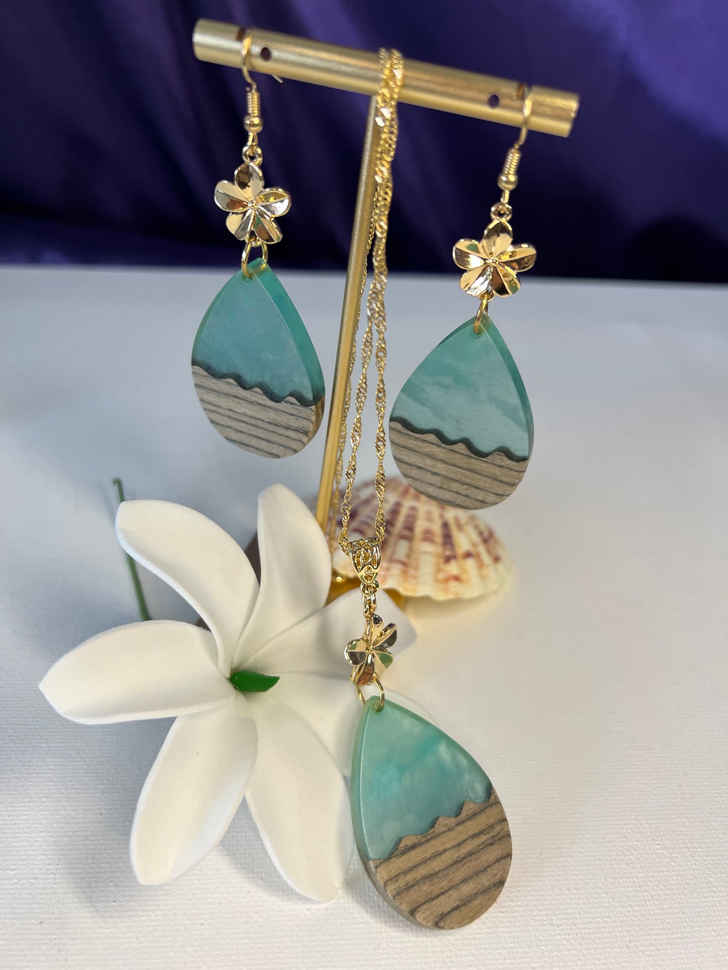 Teal risen ocean waves with wood complemented with plumeria flower