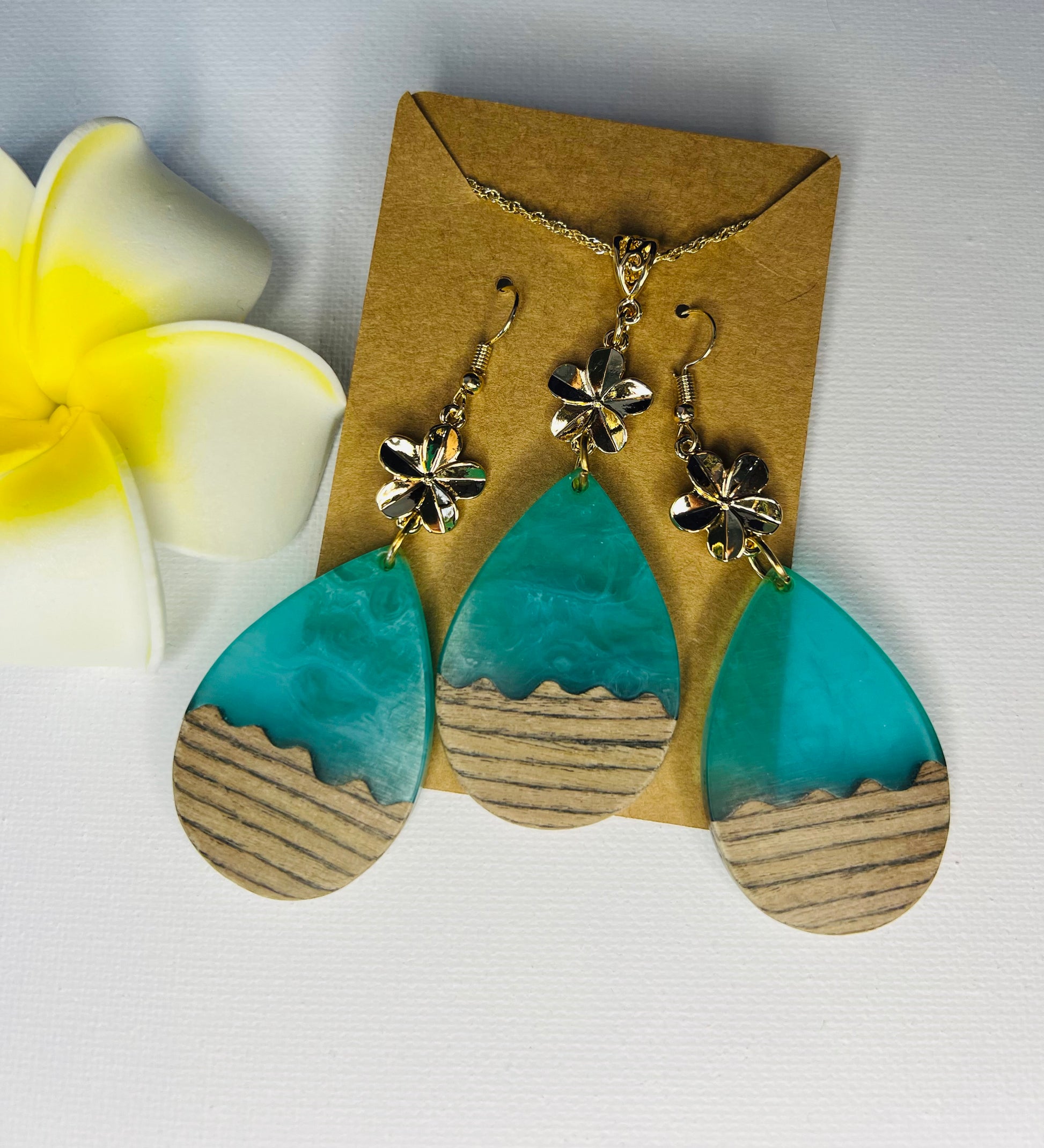 Teal risen ocean waves with wood complemented with plumeria flower