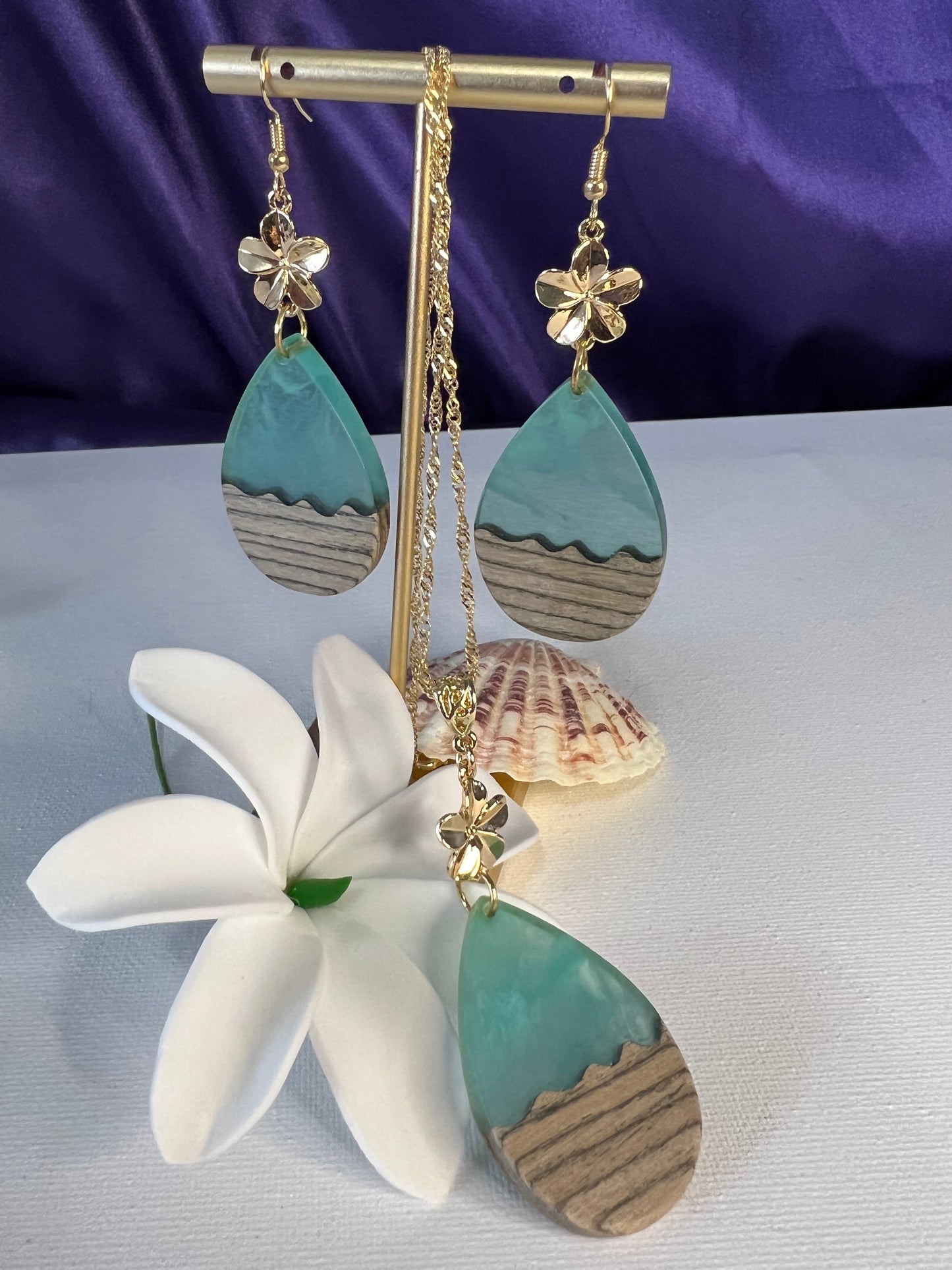 Teal risen ocean waves with wood complemented with plumeria flower